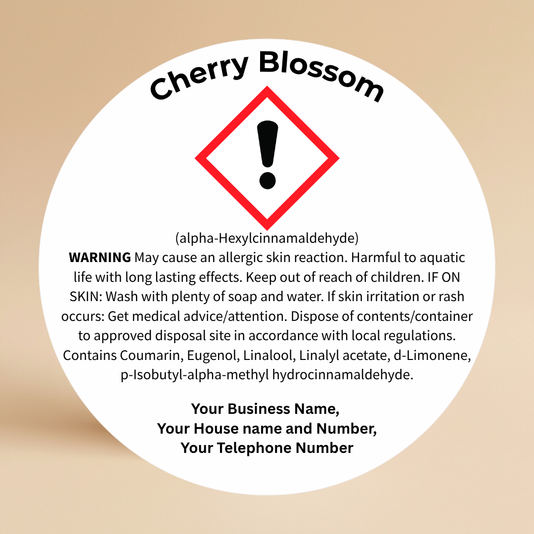 Close-up of a Cherry Blossom CLP candle warning label with safety information on a round sticker, shown clearly on a neutral background.